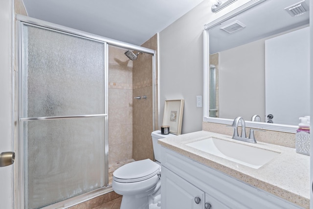 bathroom with vanity, toilet, tile patterned flooring, and a shower with door