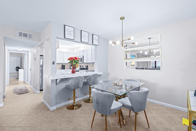 tiled dining room with an inviting chandelier