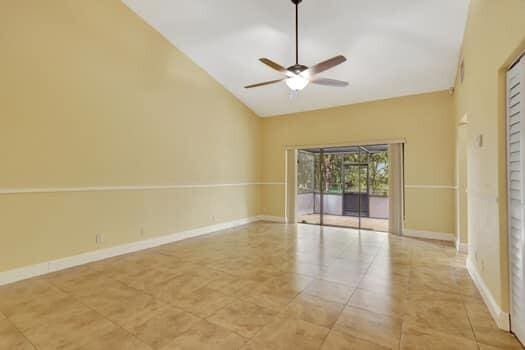 unfurnished room with high vaulted ceiling, ceiling fan, and light tile patterned floors