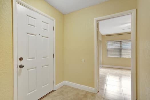 doorway to outside with light tile patterned flooring