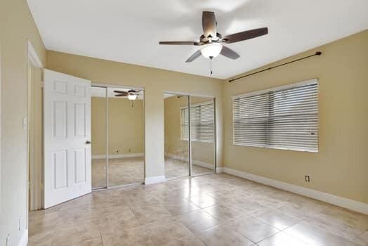 unfurnished bedroom featuring two closets and ceiling fan