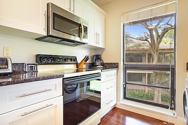 kitchen featuring white cabinetry, electric range oven, dark stone countertops, and dark hardwood / wood-style floors