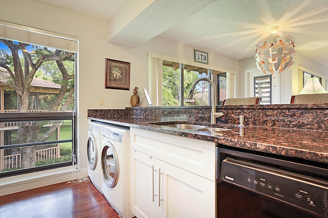 laundry room featuring a textured ceiling, separate washer and dryer, a notable chandelier, dark wood-type flooring, and sink