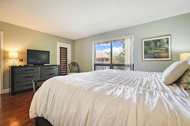 bedroom featuring dark wood-type flooring and a textured ceiling