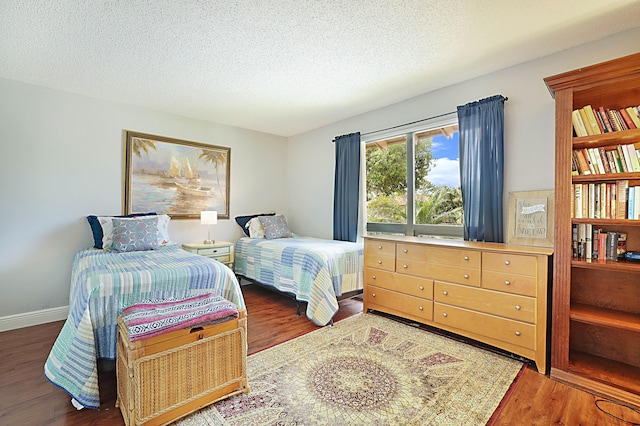 bedroom with a textured ceiling and dark wood-type flooring