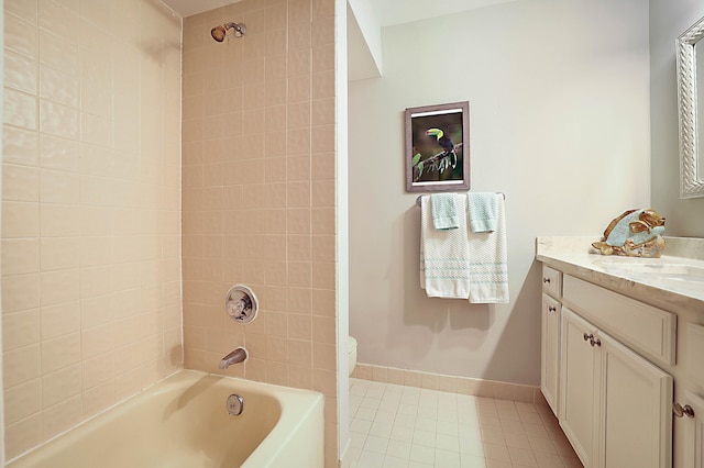 full bathroom with tile patterned floors, tiled shower / bath, toilet, and vanity