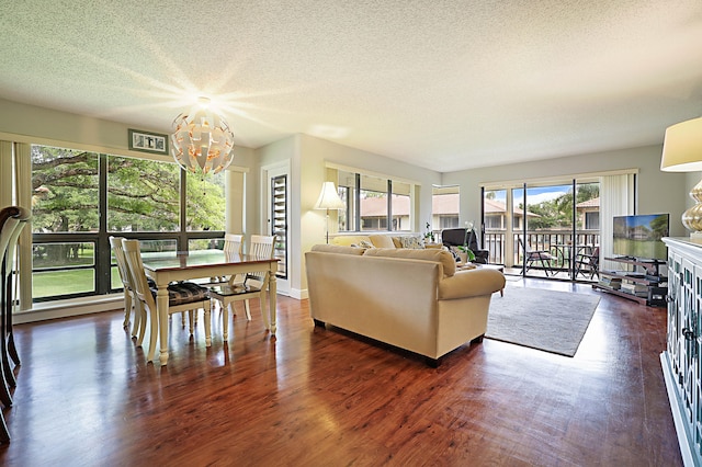 living room featuring a wealth of natural light, dark hardwood / wood-style flooring, a chandelier, and a textured ceiling