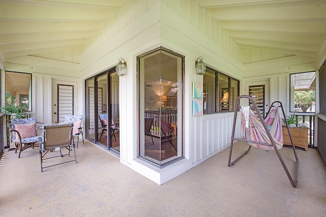 sunroom / solarium featuring lofted ceiling with beams