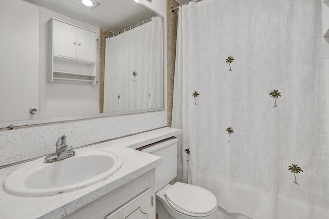 bathroom featuring curtained shower, toilet, and vanity