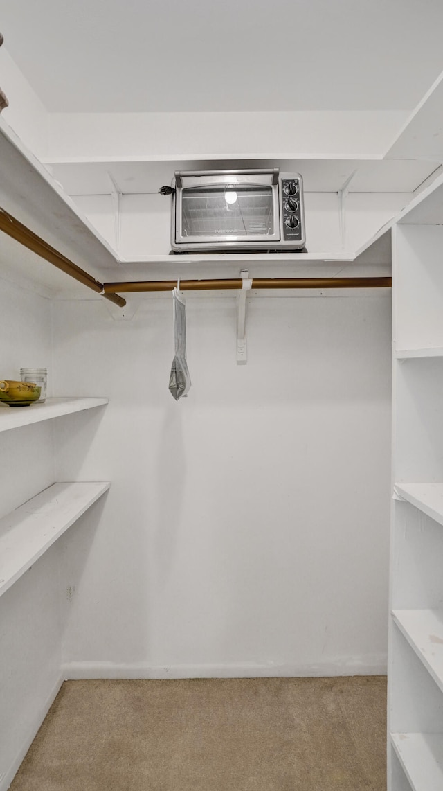 spacious closet featuring a wall unit AC and light carpet