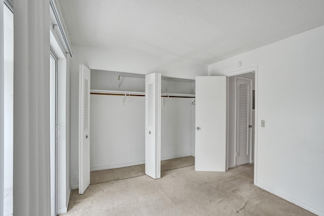 unfurnished bedroom featuring a textured ceiling, two closets, and light colored carpet