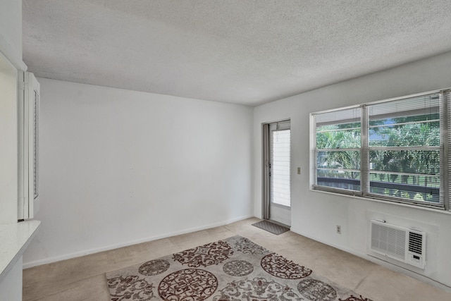 entryway with a textured ceiling and an AC wall unit