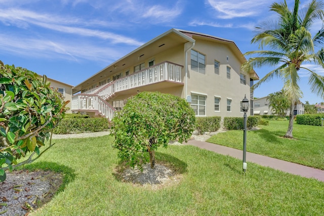 exterior space featuring a lawn and a balcony