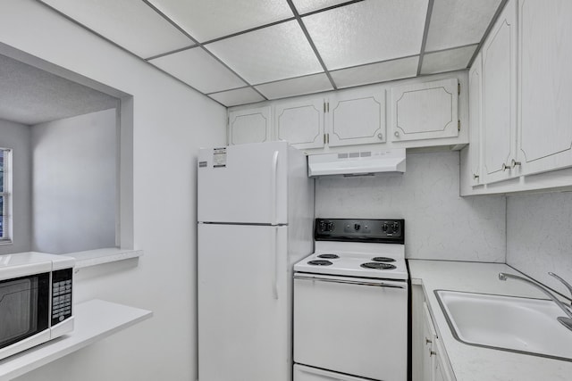 kitchen featuring white appliances, a paneled ceiling, sink, ventilation hood, and white cabinets