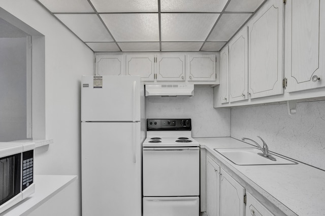 kitchen with range hood, white cabinets, white appliances, sink, and a paneled ceiling