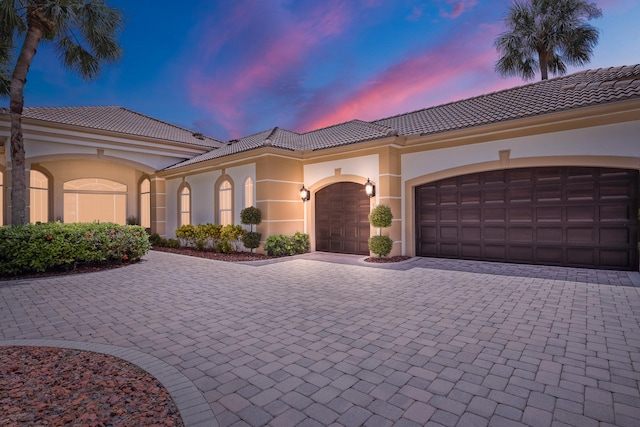 mediterranean / spanish-style house with a garage