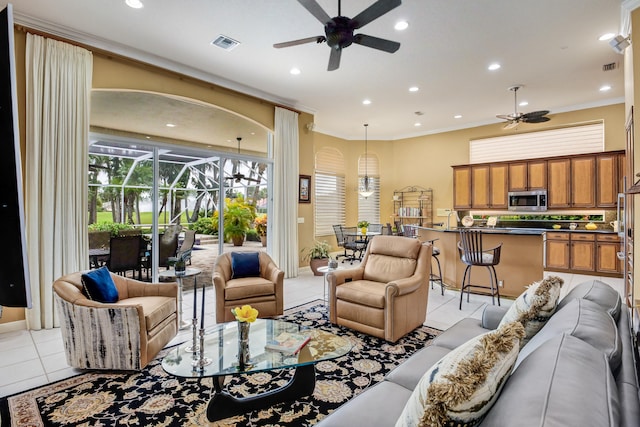 tiled living room with ceiling fan and crown molding