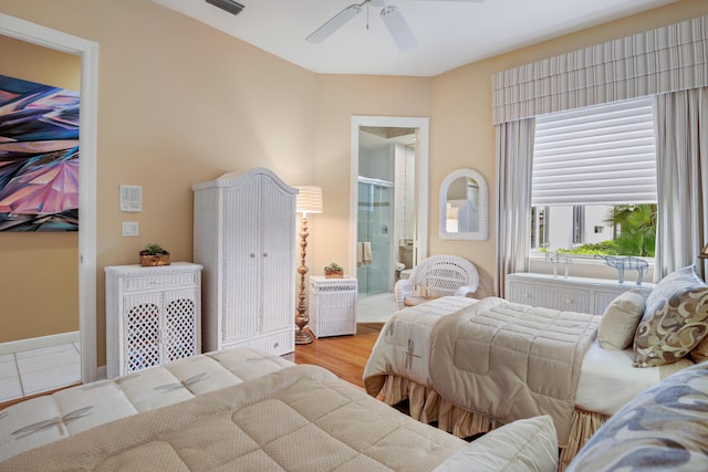 bedroom with ensuite bath, light hardwood / wood-style flooring, and ceiling fan