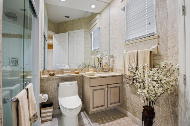 bathroom featuring vanity, toilet, walk in shower, and tile patterned floors