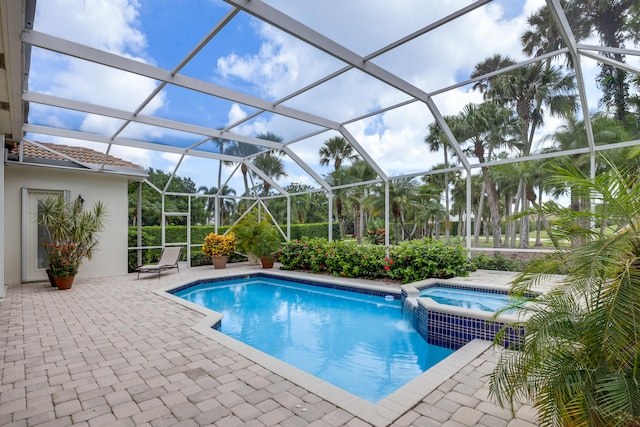 view of swimming pool with a lanai, an in ground hot tub, and a patio