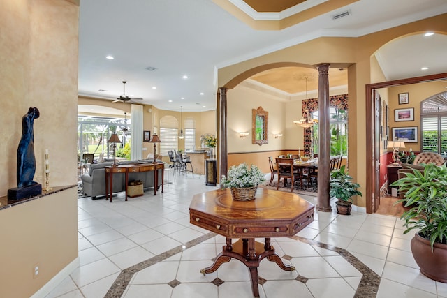 interior space featuring ornamental molding, a wealth of natural light, decorative columns, and ceiling fan