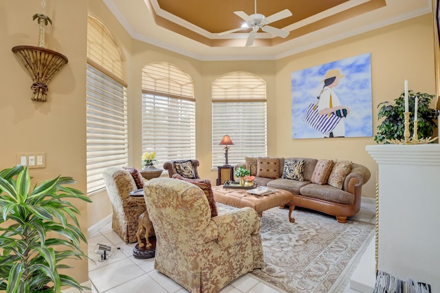 living room with crown molding, ceiling fan, light tile patterned floors, and a tray ceiling