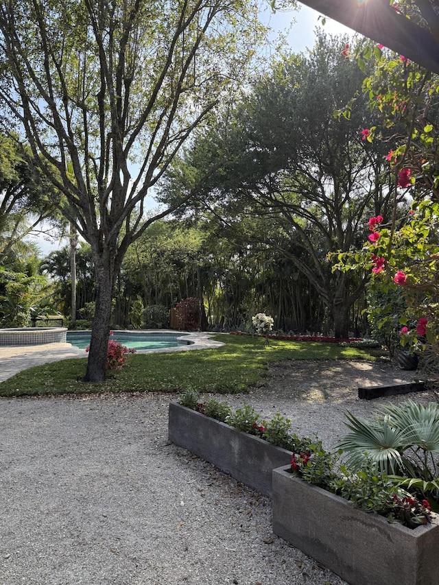 view of yard featuring a garden and an outdoor pool