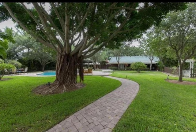 view of home's community featuring a swimming pool and a yard