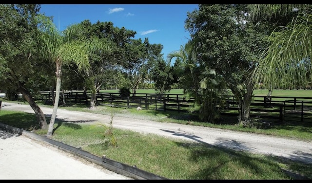 view of property's community featuring a yard, a rural view, and fence