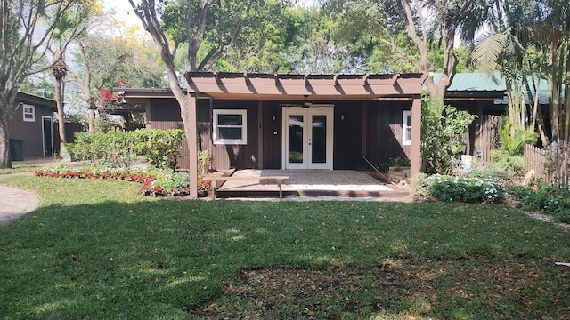 back of property with french doors, a lawn, and ceiling fan