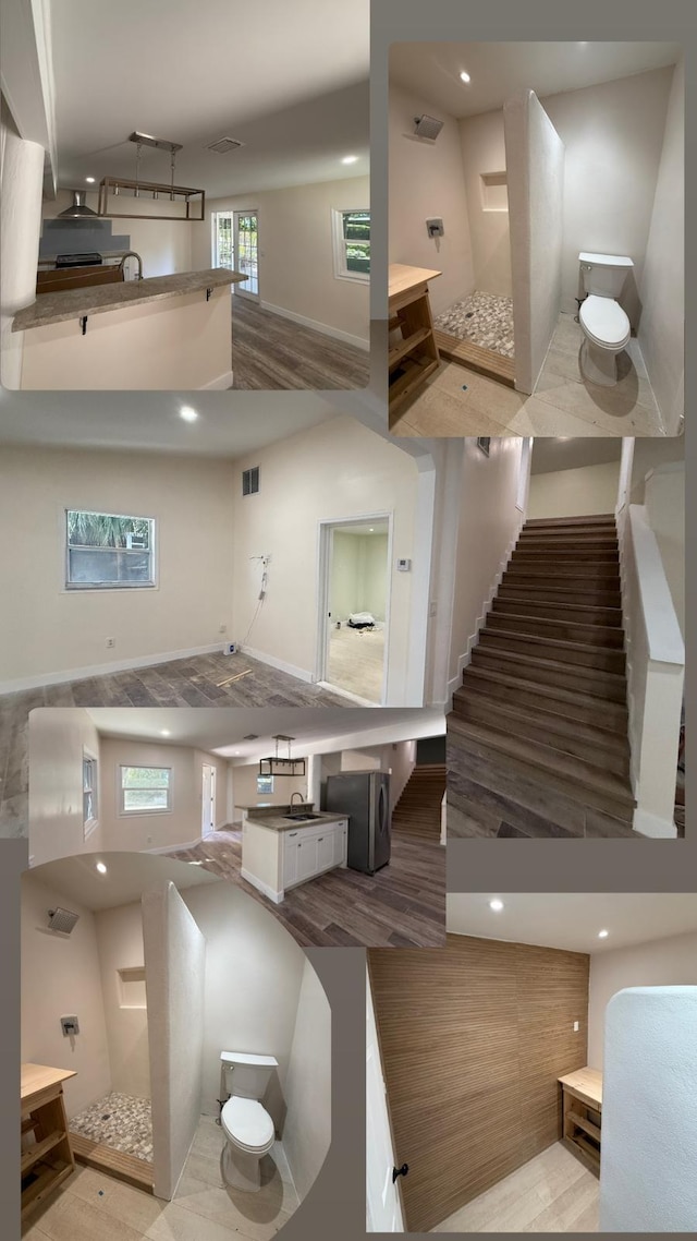 interior space featuring stairway, wood finished floors, visible vents, recessed lighting, and a towering ceiling