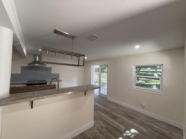 kitchen featuring dark wood-style floors, baseboards, visible vents, stainless steel range with electric cooktop, and wall chimney exhaust hood