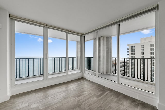 unfurnished living room with an inviting chandelier and light hardwood / wood-style flooring