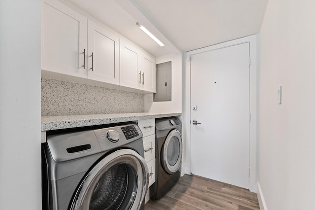 clothes washing area with electric panel, cabinets, washer and dryer, and dark hardwood / wood-style floors