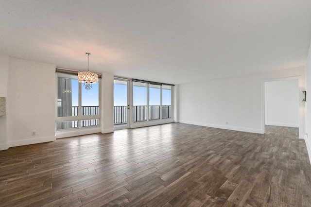 unfurnished living room with an inviting chandelier and dark wood-type flooring