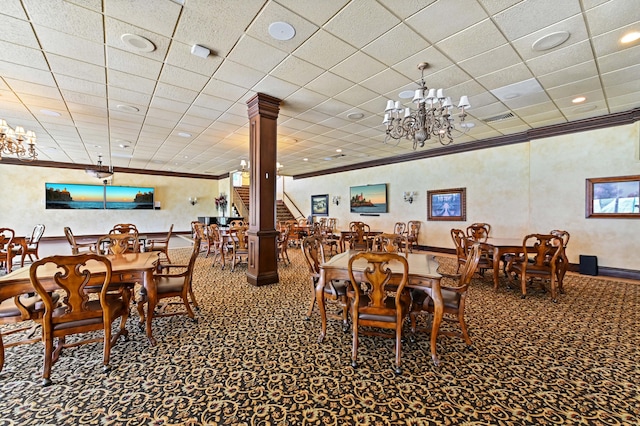 dining area featuring carpet floors, an inviting chandelier, ornate columns, and ornamental molding