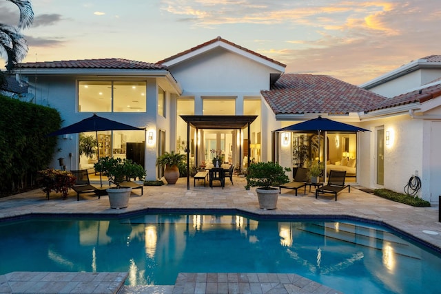 back house at dusk with a patio