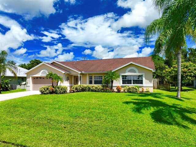 ranch-style home with a garage and a lawn