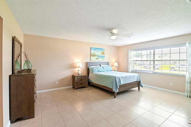 bedroom featuring a textured ceiling, ceiling fan, and light tile patterned flooring