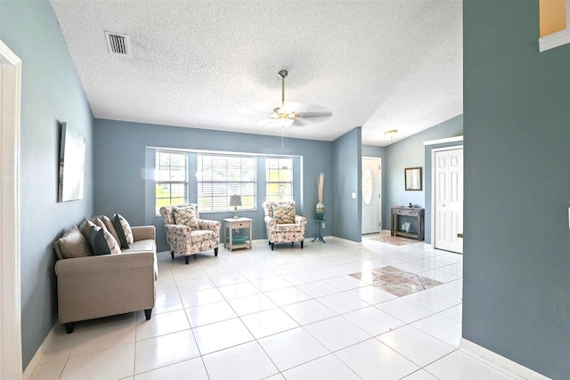 tiled living room with lofted ceiling, a textured ceiling, and ceiling fan