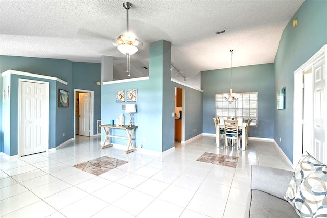 unfurnished living room with high vaulted ceiling, ceiling fan, light tile patterned flooring, and a textured ceiling