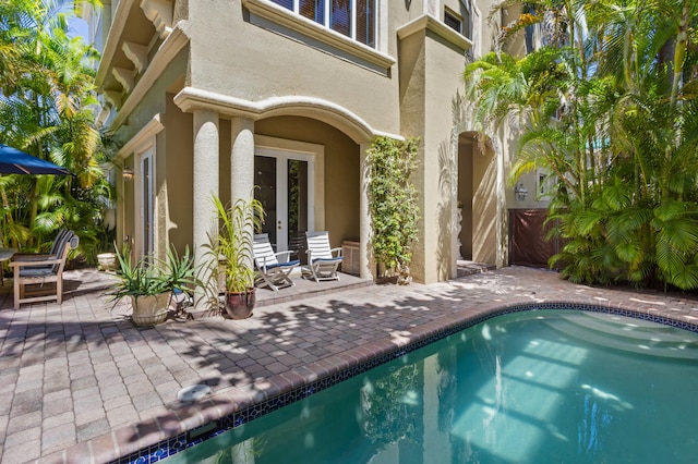 view of swimming pool featuring french doors and a patio area