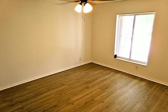 spare room with dark hardwood / wood-style flooring and ceiling fan