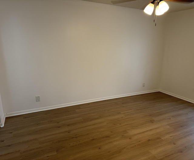 spare room with dark wood-type flooring and ceiling fan