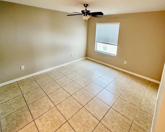 empty room with ceiling fan and light tile patterned floors