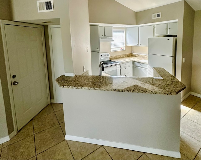 kitchen with kitchen peninsula, light stone counters, light tile patterned floors, and white appliances