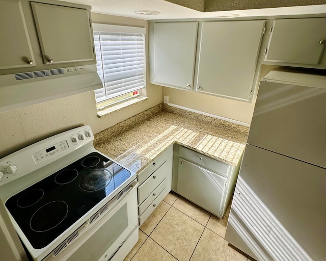 kitchen with light tile patterned floors, refrigerator, and white electric range