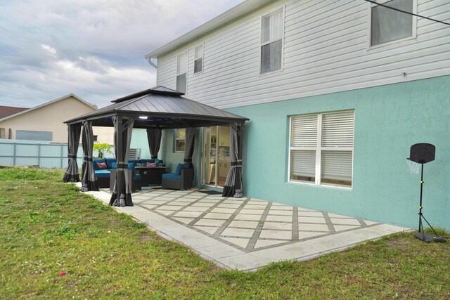 rear view of property featuring a gazebo, an outdoor living space, a patio area, and a lawn