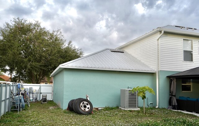 view of side of property with a lawn and central air condition unit