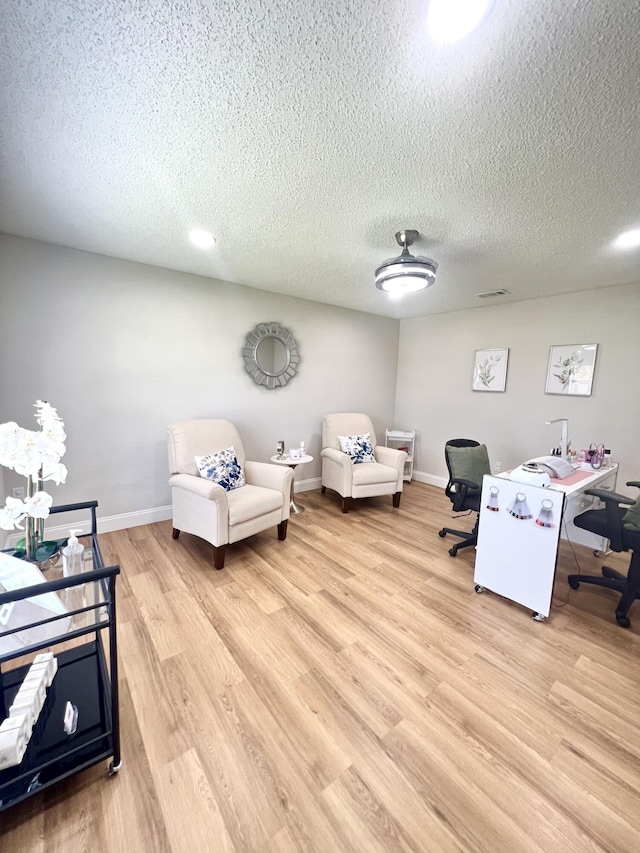 office space with light hardwood / wood-style floors and a textured ceiling